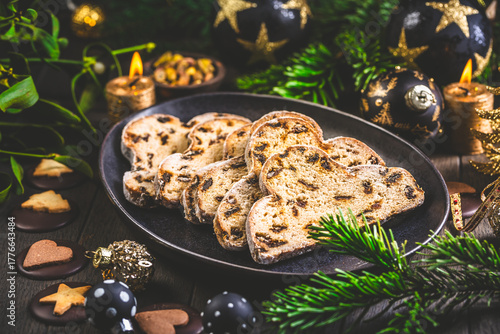 Traditional christmas stollen fruit cake with cookies on  festive table