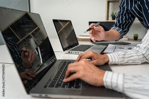 Business trader team typing stock data on laptop and pointing statistic graph to brainstorming about stock market