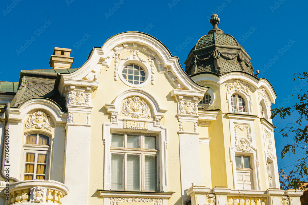 Fototapeta premium Elegant historic building with ornate architectural facade and domed roof under clear blue sky