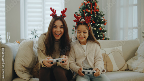 Family bonding time during the holidays while playing video games in a cozy living room decorated for Christmas