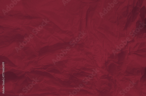 Dark red paper background displays crumpled texture, ideal for use in graphic design, presentations, or artistic displays. The vivid color adds energy to visual projects. Copy space for Christmas Xmas