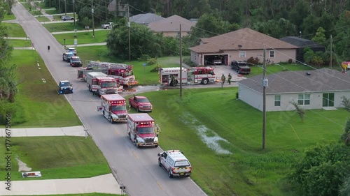 First responders arrived at fire alarm call ready to extinguish fire of burning house. Emergency service personnel responding to potential fire hazard at Florida home.