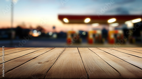 Fototapeta Naklejka Na Ścianę i Meble -  Rustic wooden plank platform with a blurred gas station background. Perfect for a product display or food presentation. Add your creations to this warm scene.