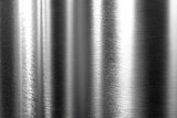 Pionowe smugi światła i cienia na powierzchni szczotkowanego metalu. Tekstura jest industrialna, z delikatnymi poziomymi zarysowaniami i mocnym blaskiem.