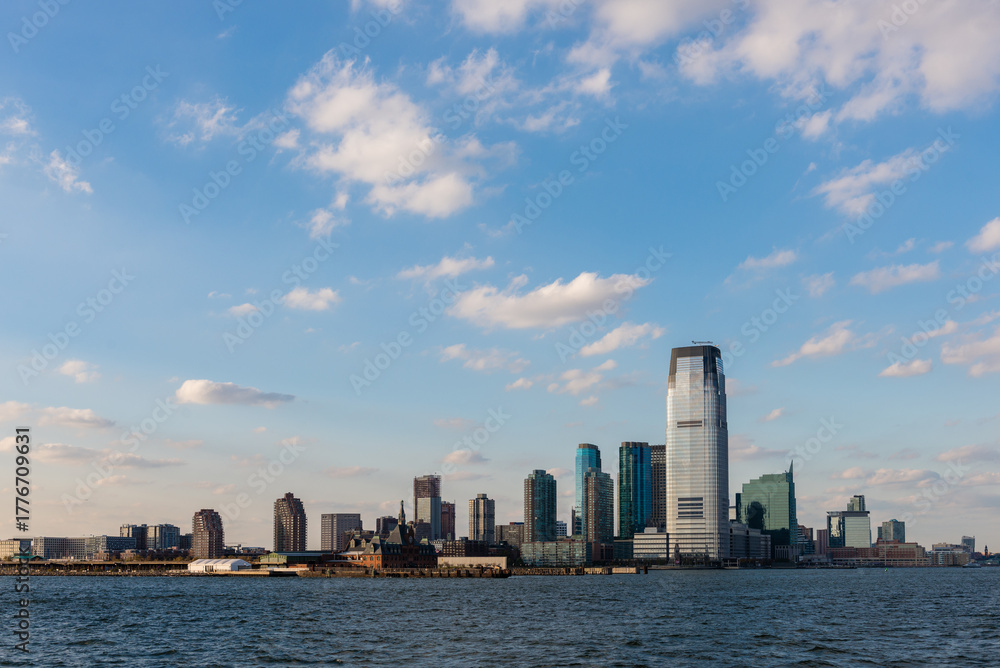 Obraz premium New York City, NY, USA. October 17, 2014: Skyline of Jersey City with skyscrapers under a blue sky viewed from the Hudson River.