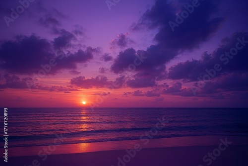 Dramatic purple and magenta sunset over the ocean with sun reflection