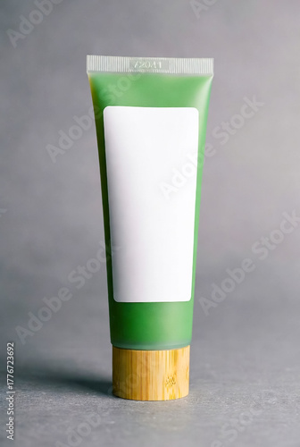Wallpaper Mural A green cosmetic tube with a blank white label stands upright on a wooden cap. Clean, modern packaging ideal for skincare products, lotions, or creams. Neutral background highlights product details. Torontodigital.ca
