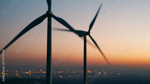Fototapeta Naklejka Na Ścianę i Meble -  Wind turbines stand tall against a backdrop of twilight skies and softly glowing city lights, symbolizing a modern and sustainable energy landscape.