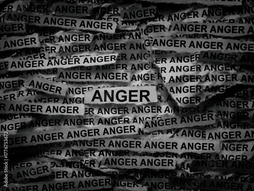 Strips of newspaper with the words Anger typed on them. Black and white. Close up.