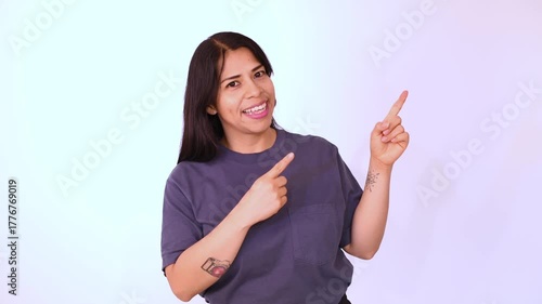 Woman in a blue T-shirt pointing to the right, isolated on a white background