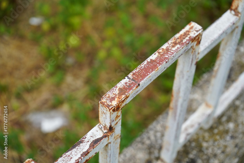 Close-up of a rusty metal railing with peeling paint and corrosion