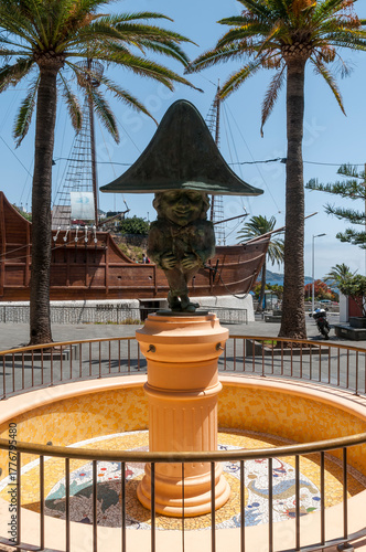 Humorvolle Kolumbus Statue vor einem Segelschiff im Hintergrund