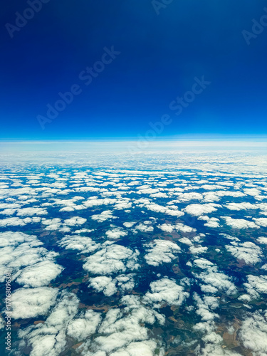 Blue sky blending with white clouds creates a serene view from above the earth, capturing the beauty of nature at midday