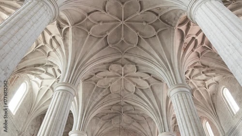 Elegant gothic architecture with star-shaped ribbed vaults and massive stone columns inside the historic church of Roa, in Burgos, Spain. A serene and majestic view of sacred heritage and symmetry.