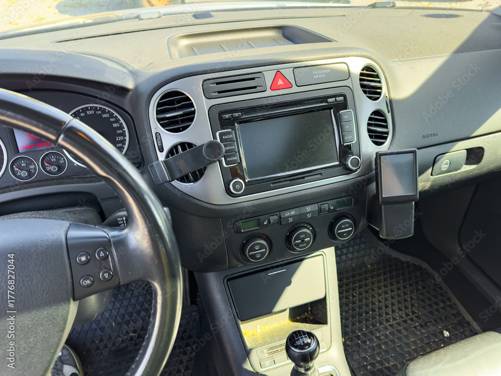 Naklejka premium Modern car interior with advanced dashboard features showcasing radio and climate controls in bright daylight