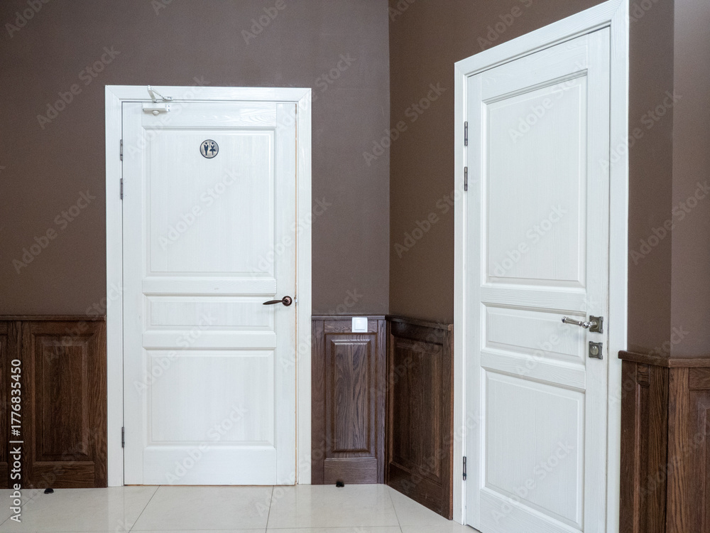 Fototapeta premium Interior of a hotel room with two white doors and a wooden door