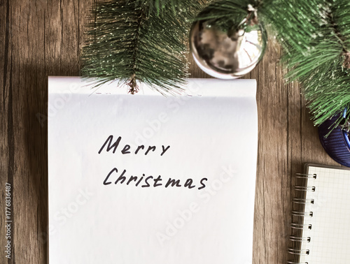 Merry Christmas is handwritten on the paper, and next to it is a Christmas tree with toys