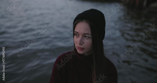 Closeup lonely girl resting near a lake at the dusk