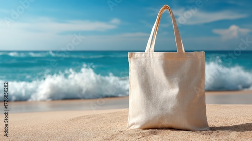 Soft waves crash gently on the shore while a tote bag stands on the sand inviting beachgoers to relax.
