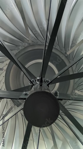 A view from inside an air duct showing a rotating deflector and stainless steel grille in a ventilation system design for an industrial restaurant building.