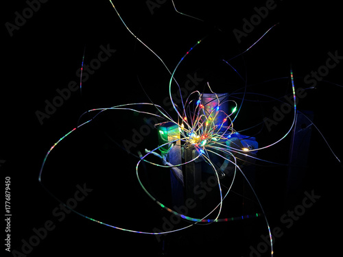 Background with a colorful string of lights in the shape of a fantasy flower in the dark