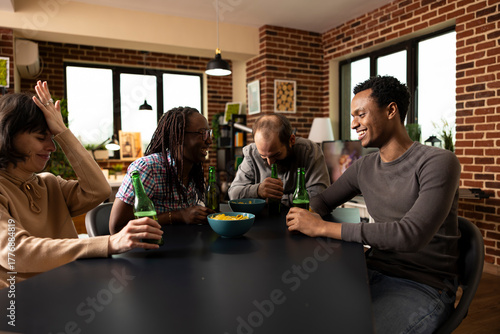 фотографія Men and women share laughter over funny joke, enjoying drinks and snacks in brick wall room