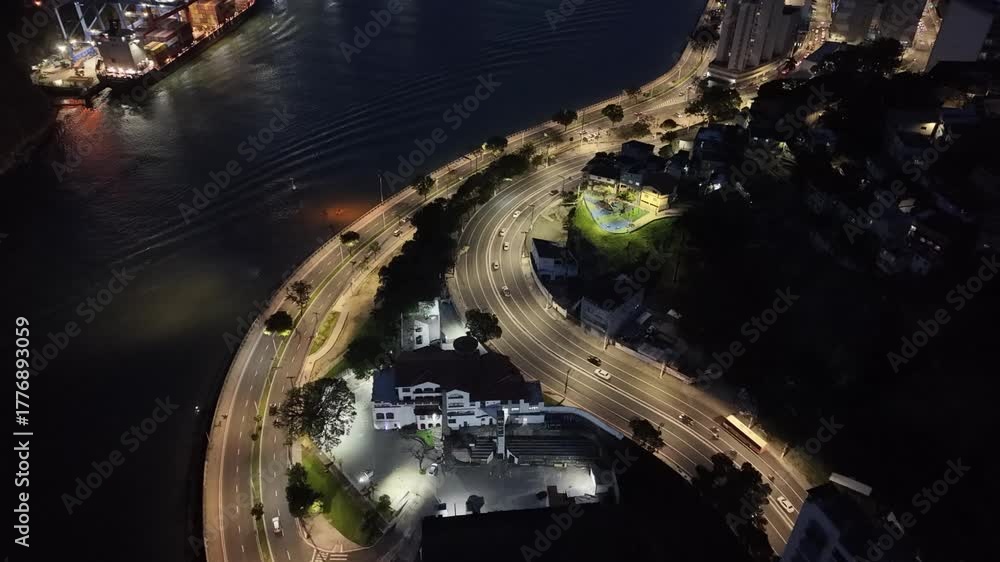 imagem aérea da cidade de Vitória a noite, mostrando o canal de vitória, o porto, as principais vias da cidade e a região comercial.