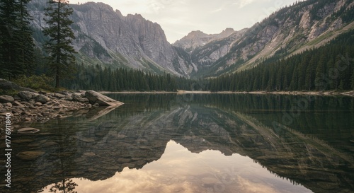 Glassy Alpine Lake Mirrors Rugged Peaks and Pine Forest in a Serene Valley