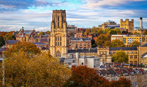 Bristol University’s Wills Memorial Building surrounded by historic city architecture and autumn trees under a vibrant sky.