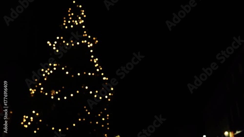 Christmas wallpaper in minimalist style.Christmas tree silhouette made of garlands on a dark sky background.Christmas and New Year mood. 4k footage
