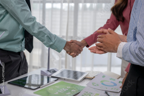 Foto Business people shaking hands celebrating green energy esg deal
