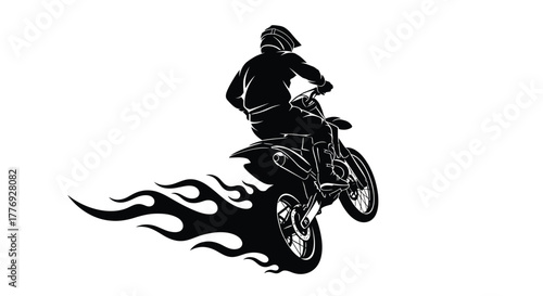 Silhouette of a motocross rider performing a jump with flames