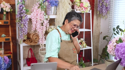 Asian senior woman, florist, small business, owner, entrepreneur manage store accounting with laptop at flower shop, independent lifestyle, creative workspace, passion for business, and modern skills