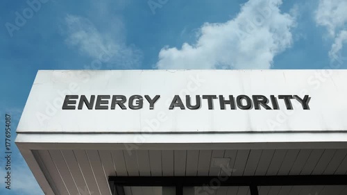 Energy Authority word sign prominently displayed on the official government building facade beneath a clear blue sky, signifying the body responsible for regulating power, fuel, and resources