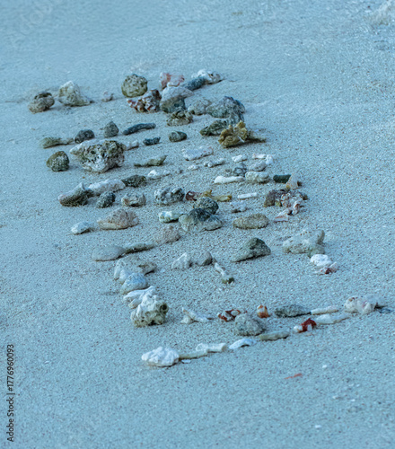 Mot “Moorea” écrit sur le sable avec des coraux et coquillages – Polynésie française