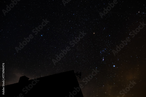 Tableau sur toile Beautiful night sky filled with stars and a rural cottage beneath it