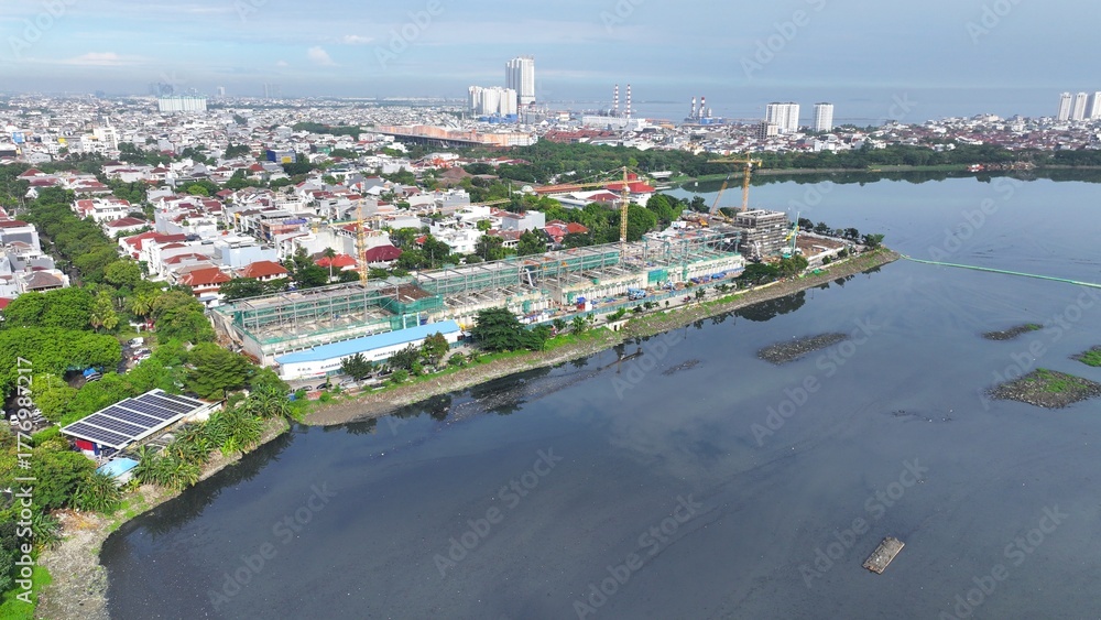 Obraz premium Aerial view Construction site with a crane and a large building in the background. The crane is on the left side of the image and the building is on the right side. middle city 