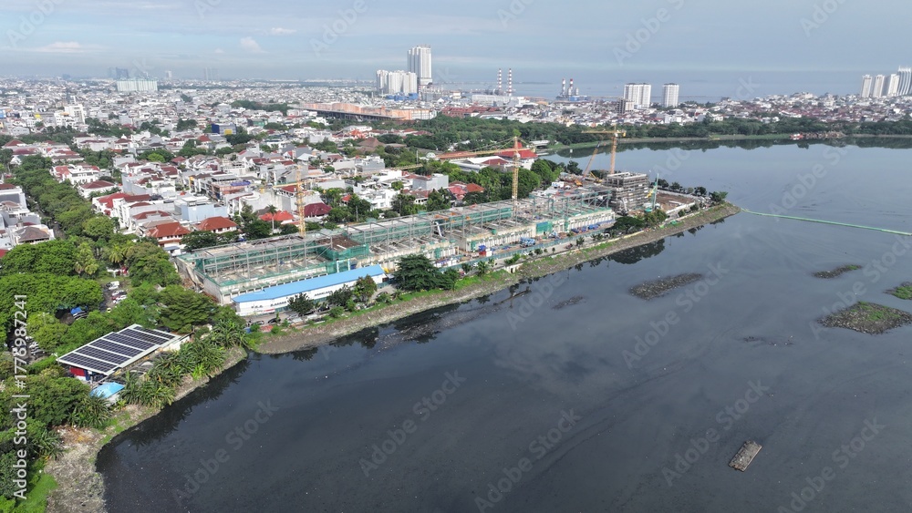 Obraz premium Aerial view Construction site with a crane and a large building in the background. The crane is on the left side of the image and the building is on the right side. middle city