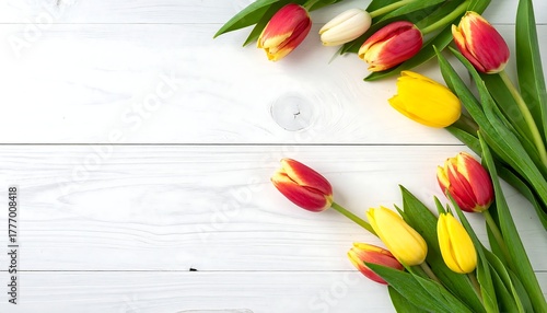 Overhead shot of colorful tulips on a white wooden background