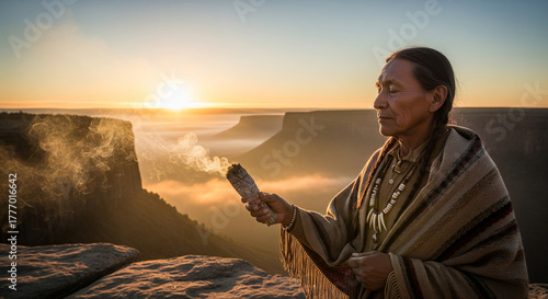 An Indigenous elder performs a spiritual ritual with smoke against a stunning sunset backdrop.