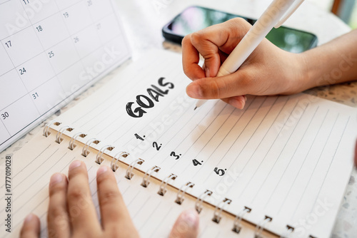 Close-up of a hand writing the word goals 2026 in a notebook. New year planning, goal setting and motivation concept