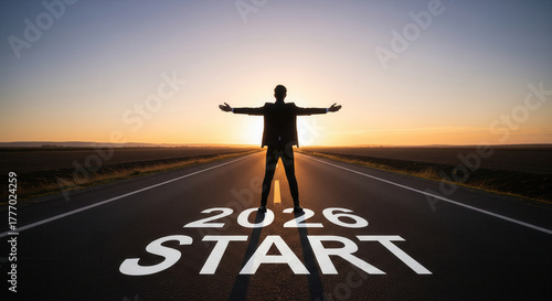 Confident businessperson standing on empty road at sunrise with arms wide open, facing new opportunities and fresh beginnings, 2026 start concept, hope and ambition