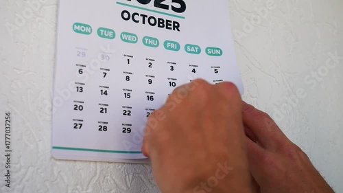 A hand tears off the calendar page followed by November one with the date of Black Friday 2025