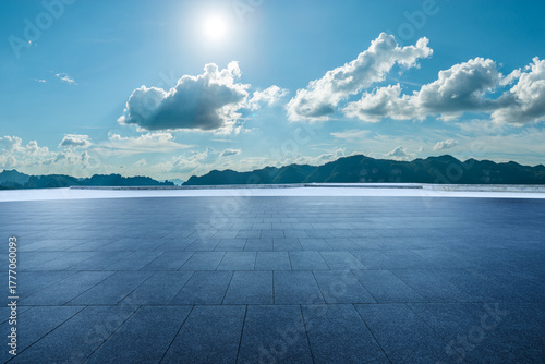 Fototapeta Naklejka Na Ścianę i Meble -  Empty square floor and mountain with beautiful sky clouds landscape under a sunny blue sky