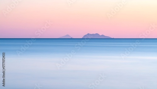 Serene ocean view at dawn or dusk, with islands in the distant background