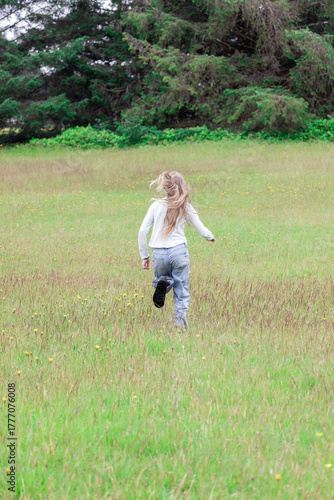 Girl running through meadows in the summer