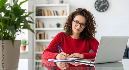 Young Woman Working from Home with Laptop and Notebook.