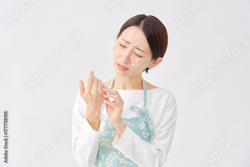 エプロンをつけた女性　手のあかぎれ・ひび割れ　白背景