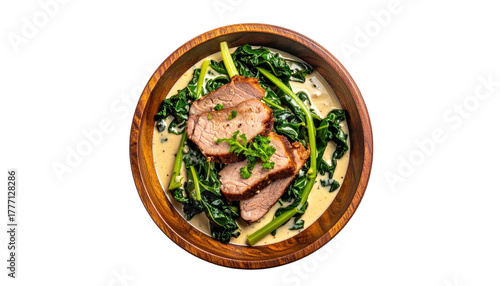 Pork tenderloin with creamed spinach in a wood bowl, top view