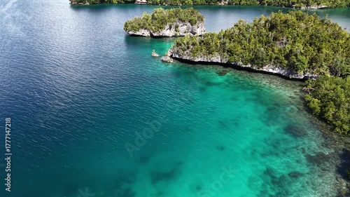 Aerial view of tropical lagoons with turquoise water and lush green islands in Raja Ampat, Indonesia.	